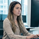 Analyst at a desk working on a computer in a bright office