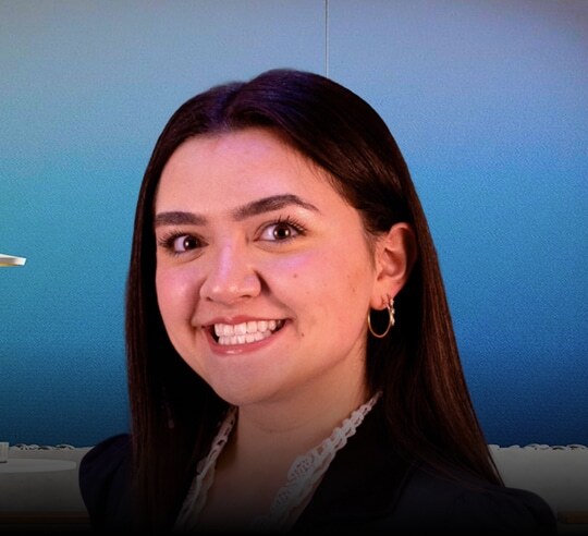 Smiling Financeable student in a black blazer against a blue background