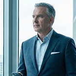 Senior banker in a suit looking out an office window
